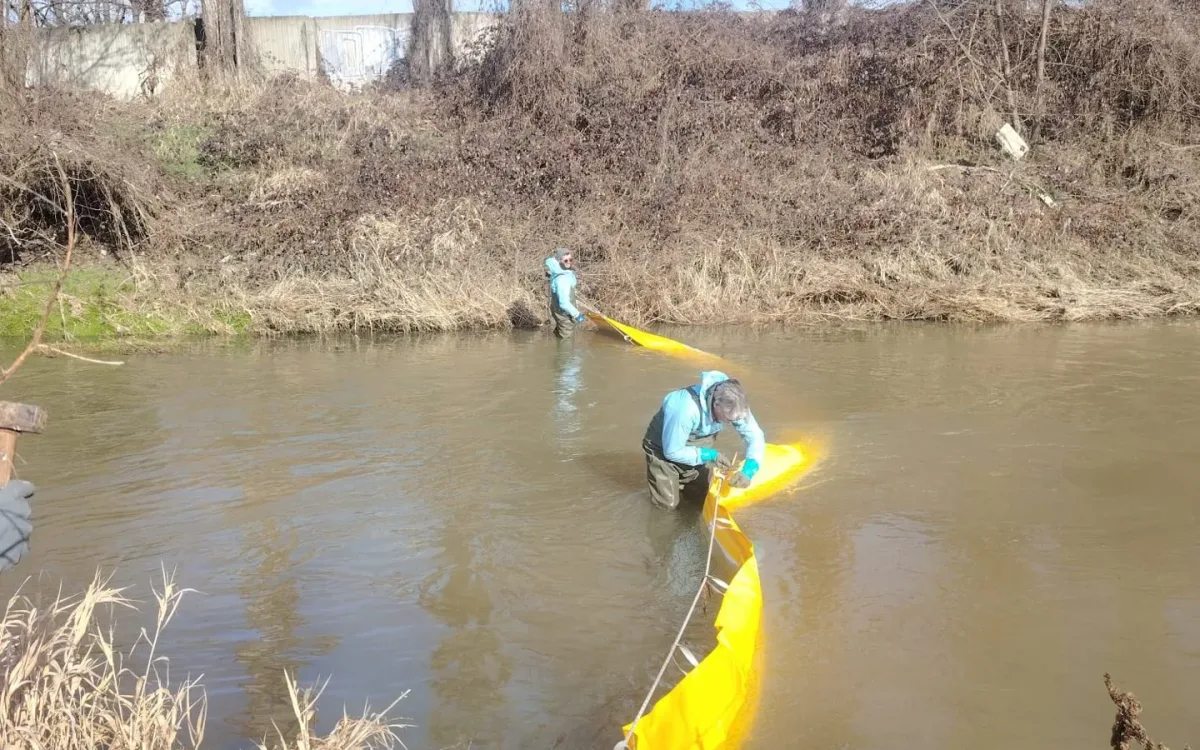 Barrier anchored to the bank with a rope during installation
