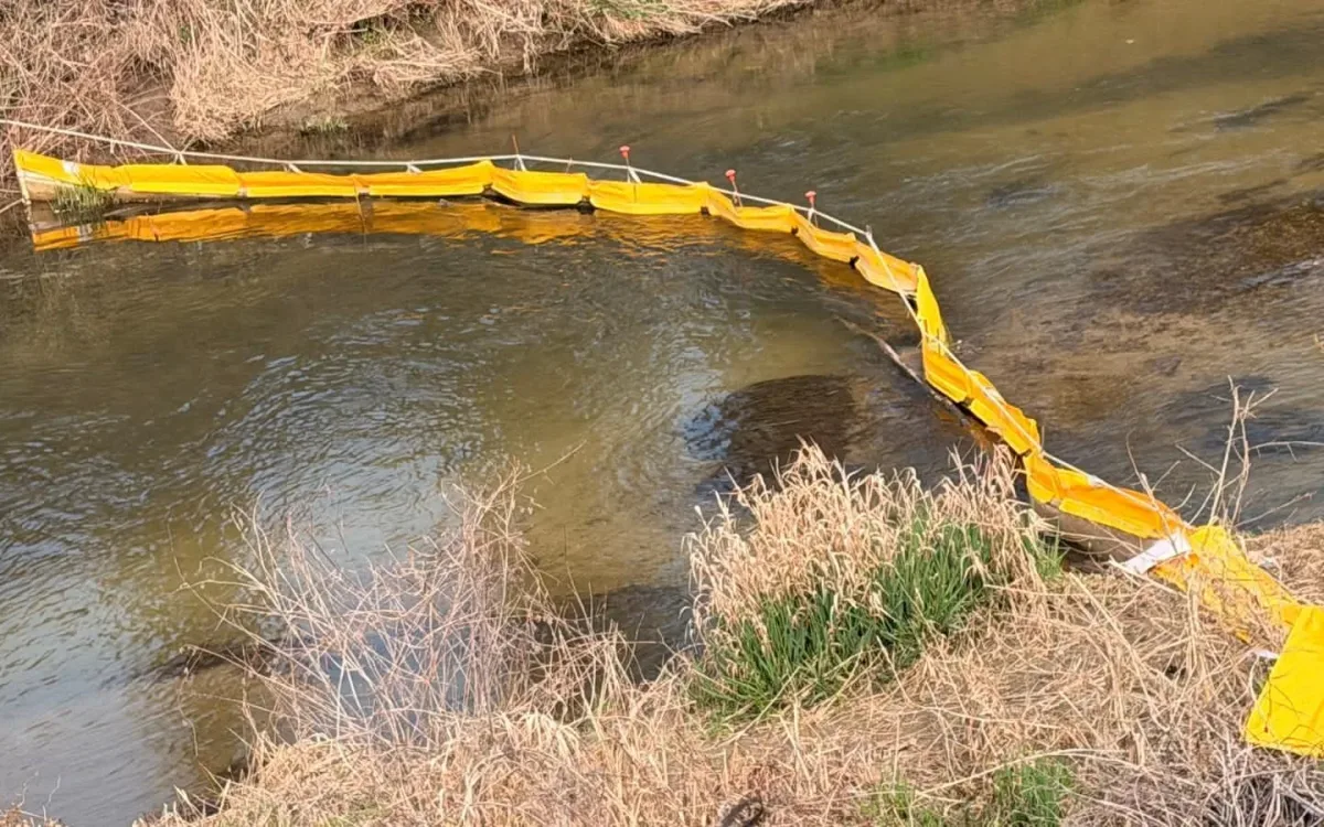 Curved barrier line anchored to the bank for continuous control