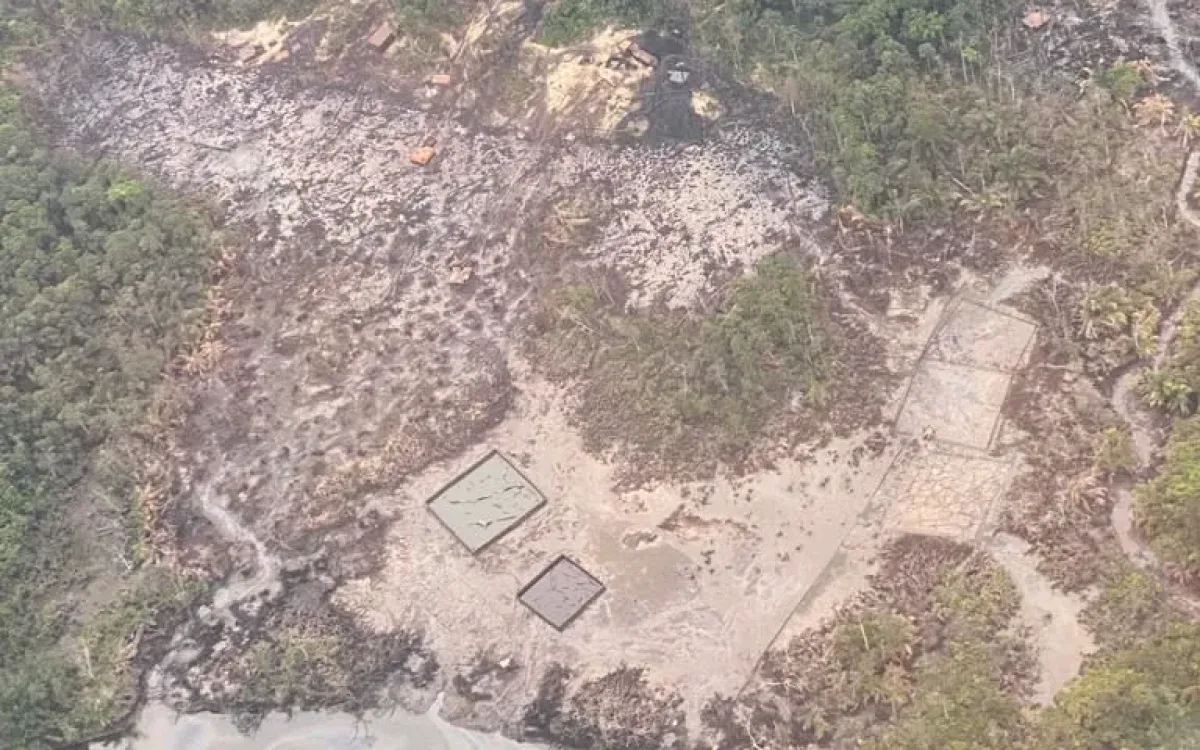 Aerial view of cleared land and a stream with oil along the bank in the Niger Delta, Nigeria