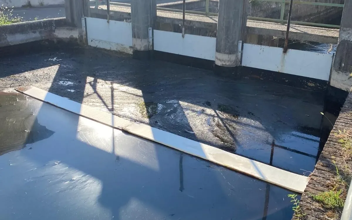 White absorbent strip placed on the water in front of the sluice gates