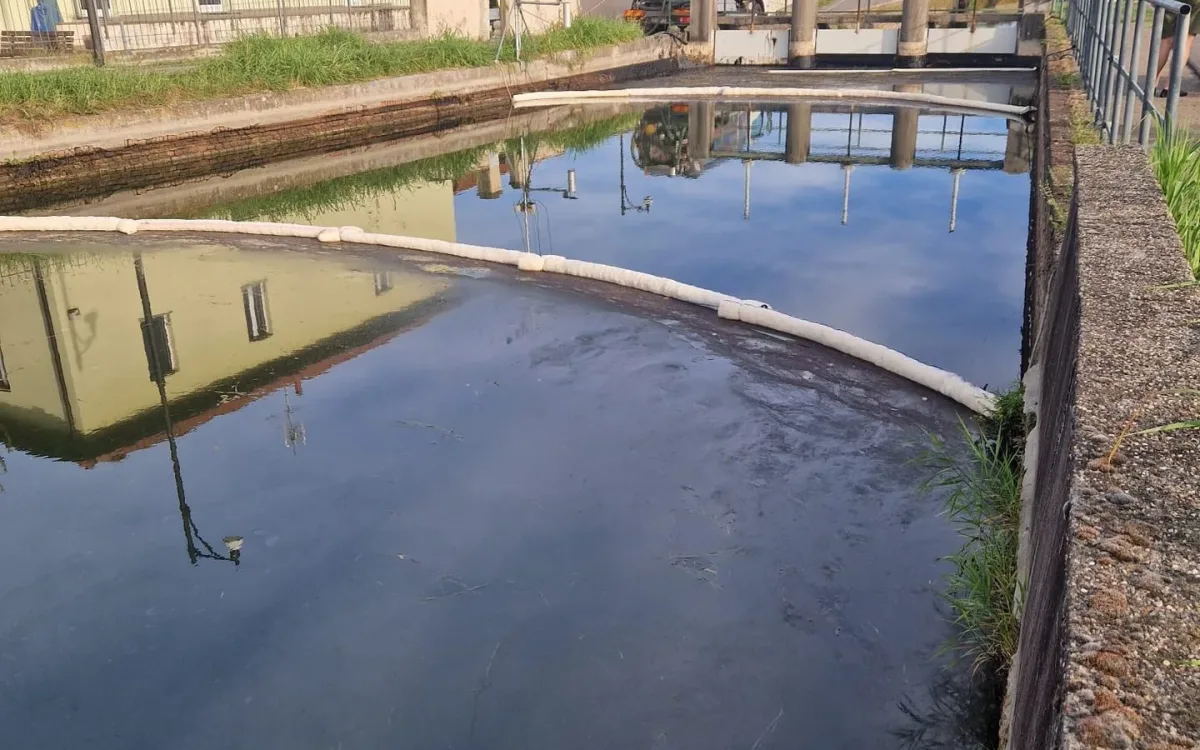 FoamFlex absorbent line curving across the canal in front of the sluice gates at Abbiategrasso
