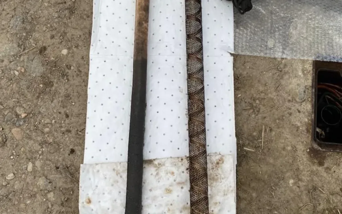Used absorbent sock and perforated steel cage laid on absorbent sheets