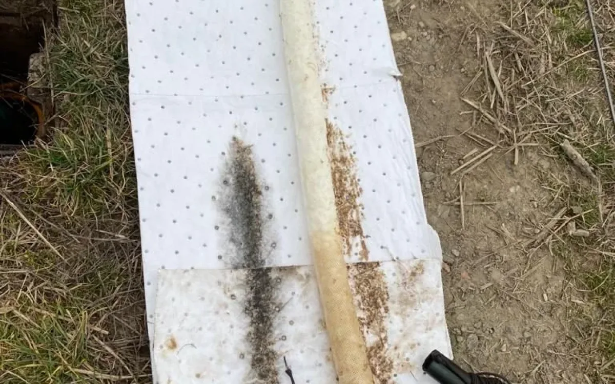 New white absorbent sock beside a used sock darkened by hydrocarbons
