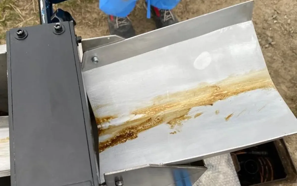 Recovered oil running down the stainless chute of the wringing unit